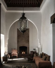 a living room filled with furniture and a fire place in the middle of an archway