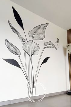 the wall is painted with black and white flowers in an empty room next to a lamp