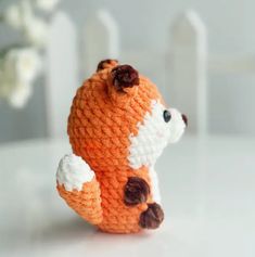 an orange and white stuffed animal sitting on top of a table