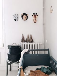 a baby crib in the corner of a room with two giraffes on the wall