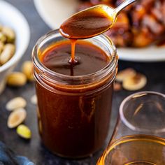 a spoon full of honey sitting next to some nuts