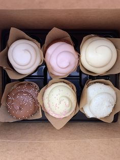 an open box filled with different types of doughnuts on top of each other