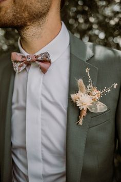 a man wearing a gray suit with a flower boutonniere on his lapel