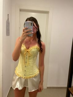 a woman taking a selfie in a yellow corset