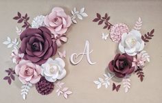 paper flowers and leaves are arranged in the shape of letters