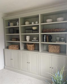 a large bookcase filled with lots of books and wicker baskets on top of it