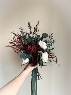 a person holding a bouquet of flowers in their hand