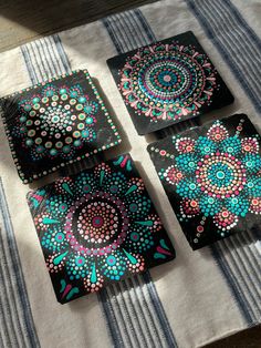 three coasters with designs on them sitting on a table