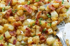 a close up of a plate of food with potatoes and bacon on it next to a fork