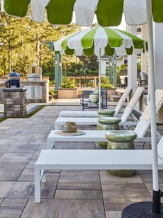 several lawn chairs and umbrellas are lined up on the patio