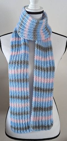 a white mannequin wearing a blue and pink scarf