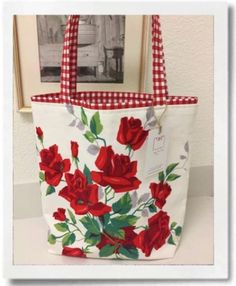 a red and white flowered tote bag sitting on top of a table