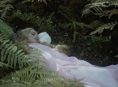 a woman laying in the grass with her eyes closed