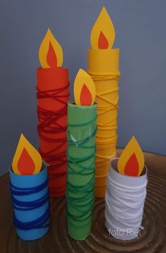 several stacks of colorful candles sitting on top of a wooden table next to each other