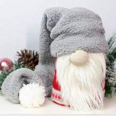 a grey and white santa clause hat sitting on top of a shelf next to christmas decorations