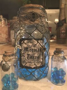 some glass jars with blue balls in them sitting on a counter next to other items