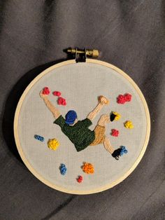 a hand embroidered picture of a man falling off his board in the air with colorful beads on it