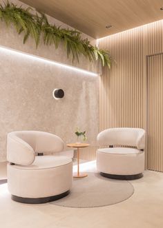 a living room with two white chairs and a round table in the middle of it