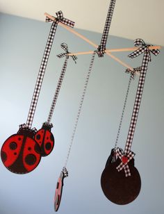 three little ladybug mobiles hanging from the ceiling