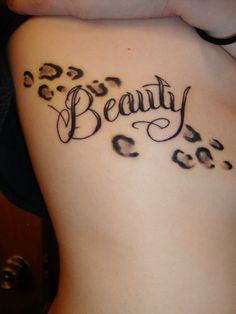 a woman's back with the word beauty written in cursive writing on it