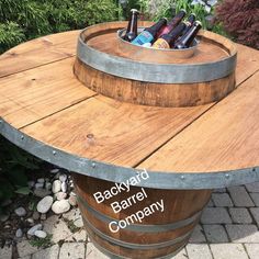 a wooden barrel table with wine bottles on top