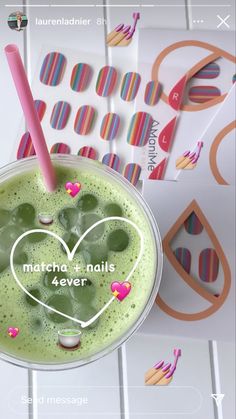 a green smoothie in a cup with pink straws on the rim and matching stickers