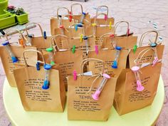 small brown paper bags filled with toothbrushes on top of a yellow round table