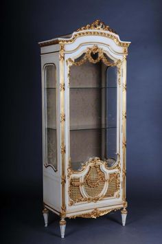 an ornately decorated china cabinet with gold trimming