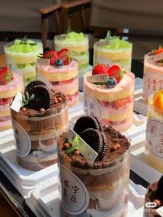 many desserts are arranged on trays for sale