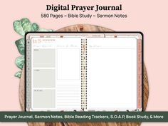 the digital prayer journal is open on top of a wooden table with leaves around it