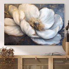 a large white flower on a blue and gold background in a living room with bookshelves