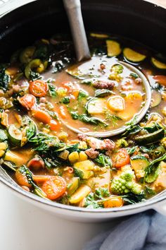 a pot filled with vegetable soup on top of a table