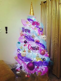 a decorated christmas tree in the corner of a living room with balloons and other decorations