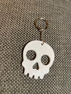 a white keychain with a skull on it