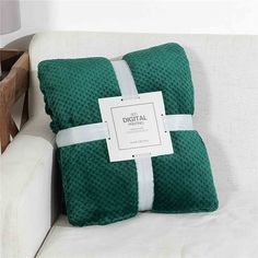 a green and white pillow sitting on top of a couch