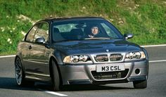 a man driving a bmw car down the road