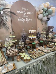 an assortment of desserts on a table at a baby shower