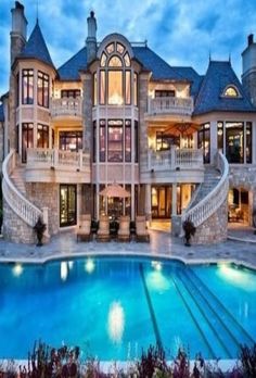 a large mansion with a swimming pool in the front yard and stairs leading up to it