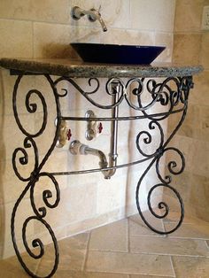 a bathroom sink sitting under a faucet next to a tiled wall