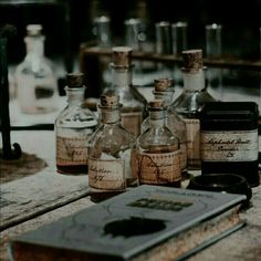 several bottles are sitting on the table with an open book in front of them,