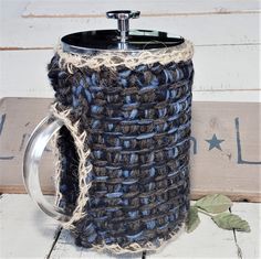 a crocheted coffee cup holder with a metal spigot on the top