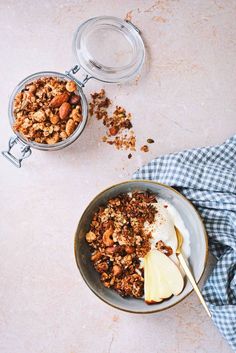 two bowls filled with granola and an apple