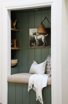 a dog is standing in the corner of a room with green painted wood paneling