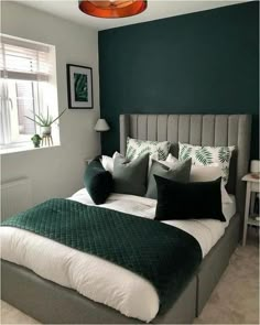 a bedroom with green walls and white bedding