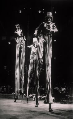 two circus clowns are standing on stage with their hands in each other's pockets