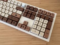 a computer keyboard sitting on top of a wooden table covered in chocolate and white keys