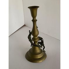 a brass colored candle holder with a dragon figurine on it