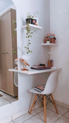 a white desk and chair in a small room with shelves on the wall behind it