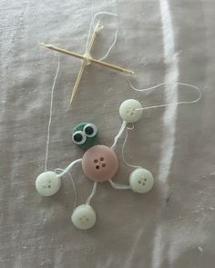 two buttons are attached to a string with a cross in the background on a bed