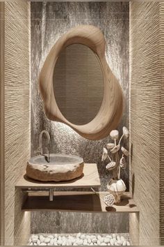 a bathroom with a sink, mirror and rocks on the floor in front of it